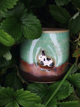 Zajačik z jesennej lúky 🍂 V objatí zemitých tónov a machovo zelenej glazúry drieme malý zajačik — ako by si práve našiel...